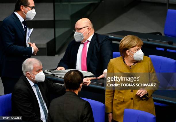 German Chancellor Angela Merkel wears a face mask as she arrives next to deputy parliamentary group leader of the conservative CSU faction Alexander...