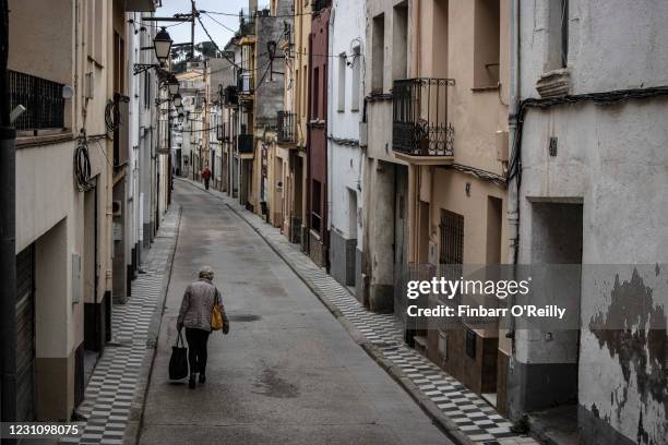 Woman walks along an empty street February 10, 2021 in the pro-independence stronghold of Arenys de Munt, a town of 9,000 residents 50 kilometres up...