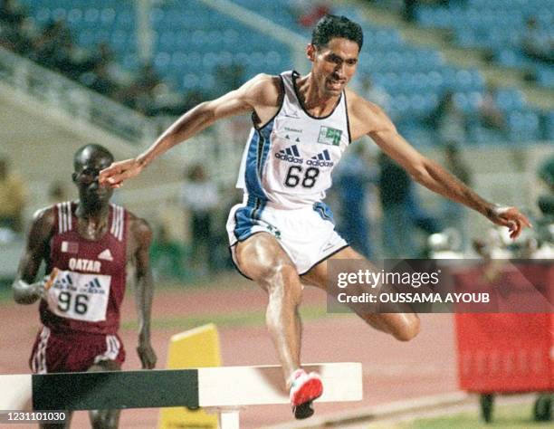 Saudi Saad Shadad Al-Asmari jumps over a hurdle on his way to win the gold medal in the 3000 meters Steeplechase at the 11th Arab Athletics...