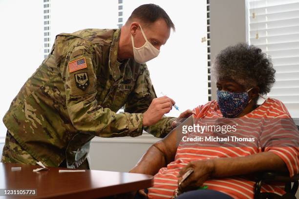 Staff Sergeant Herbert Lins of the Missouri Army National Guard administers the Covid-19 vaccine to a resident during a vaccination event on February...
