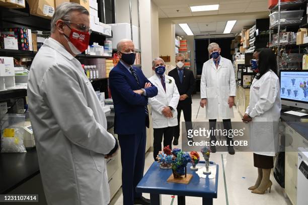 President Joe Biden tours the Viral Pathogenesis Laboratory at the National Institutes of Health in Bethesda, Maryland, February 11 flanked by Dr....