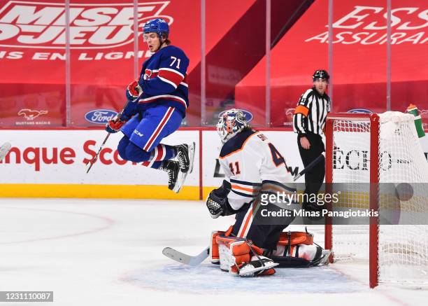 Jake Evans of the Montreal Canadiens jumps in the air in front of goaltender Mike Smith of the Edmonton Oilers during the second period at the Bell...