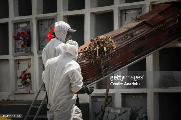 Cemetery workers exhume the body of a person buried four years ago at the Nuestra Senora de Belen cemetery, in Fusagasuga, Colombia, February 11,...