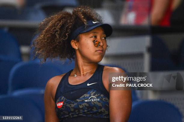 Butterfly lands on Japan's Naomi Osaka as she plays against Tunisia's Ons Jabeur during their women's singles match on day five of the Australian...