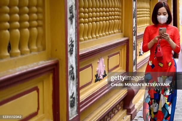 Vietnamese woman wearing a traditional Ao Dai dress leaves after offering prayers at the Tran Quoc Pagoda, one of the oldest pagodas in Hanoi on...