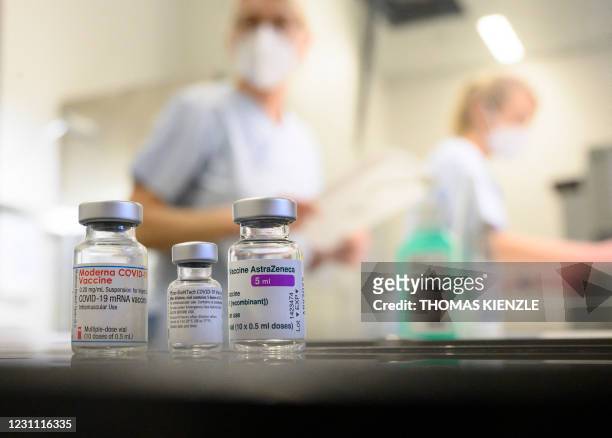 Three vials with different vaccines against Covid-19 by Moderna, Pfizer-BioNTech and AstraZeneca stand on a table in the pharmacy of the vaccination...