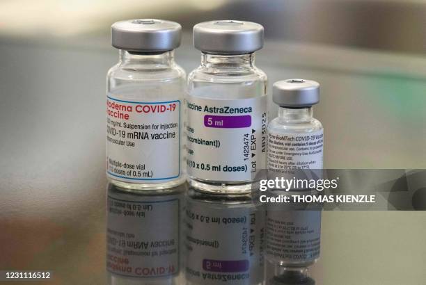 Three vials with different vaccines against Covid-19 by Moderna, AstraZeneca and Pfizer-BioNTech stand on a table in the pharmacy of the vaccination...