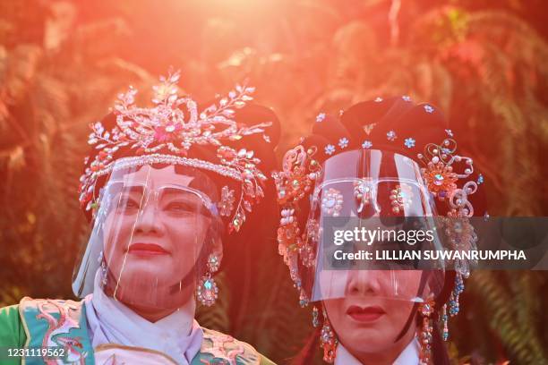 Traditional Chinese Opera performers from the Sai Yong Hong wear face shields as they entertain on the first day of the Lunar New Year in Bangkok on...