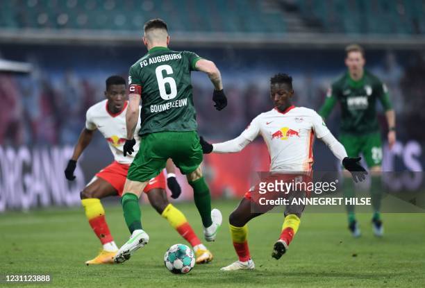 Augsburg's Dutch defender Jeffrey Gouweleeuw and Leipzig's Malian midfielder Amadou Haidara vie for the ball during the German first division...