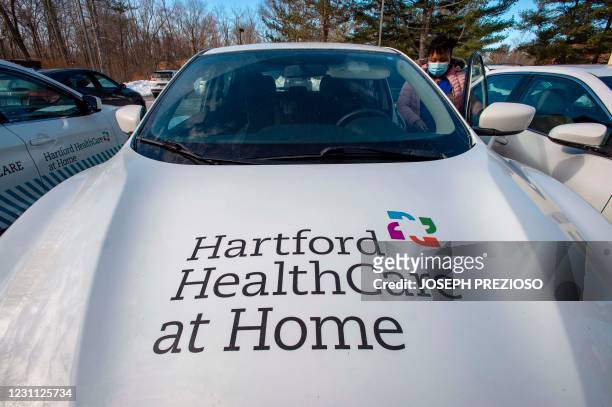 Natalie O'Connor loads a car with medical gear before heading out to visit and vaccinate patients at home with the Moderna Vaccine at Hartford...