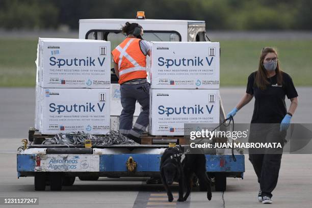 An airport worker transports shipping containers with Sputnik V vaccine doses against COVID-19, at the Ezeiza International Airport in Buenos Aires,...