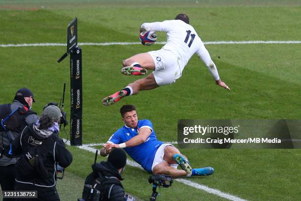 Jonny May of England scores his sides third try despite the attempted tackle of Luca Sperandio of Italy during the Guinness Six Nations match between...