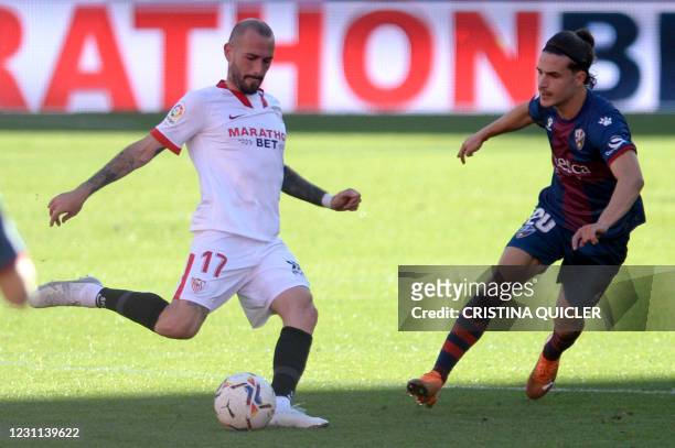 Sevilla's Spanish midfielder Alejandro Pozo vies with Huesca´s Spanish midfielder Jaime Seoane during the Spanish league football match between...