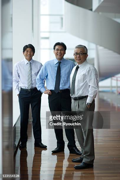 three businessmen who are standing in smile - three people ストックフォトと画像