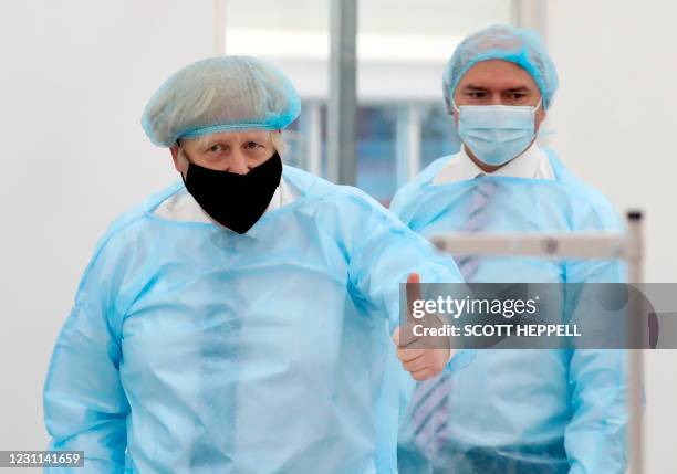 Britain's Prime Minister Boris Johnson, wearing a face mask and a hair net, visits the Northumbria Healthcare NHS Trust personal protective equipment...