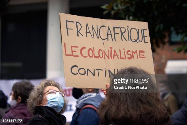 Woman looks at a placard reading 'Francafrica, colonialism still kills'. People gathered in protest against the presence of French soldiers in Mali...