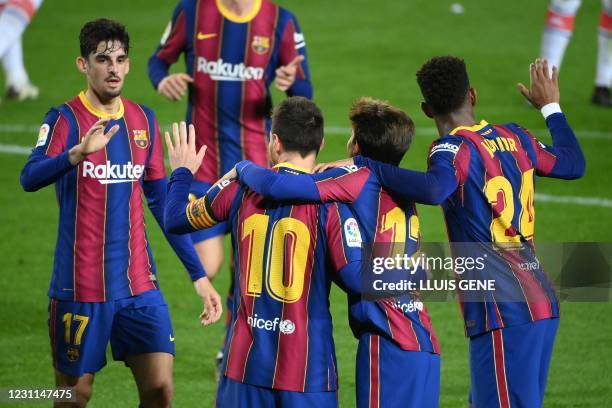 Barcelona's Argentinian forward Lionel Messi celebrates with teammates after scoring a goal during the Spanish League football match between FC...