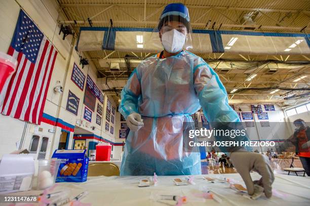 Elvin Toro a former army medic, organizes his syringes before giving out the next does to a local resident at Central Falls High School in Central...