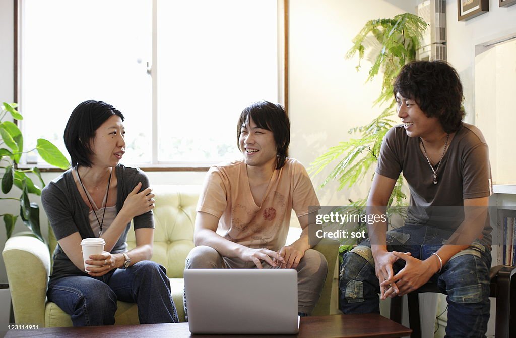 Group of three young friends talking in cafe
