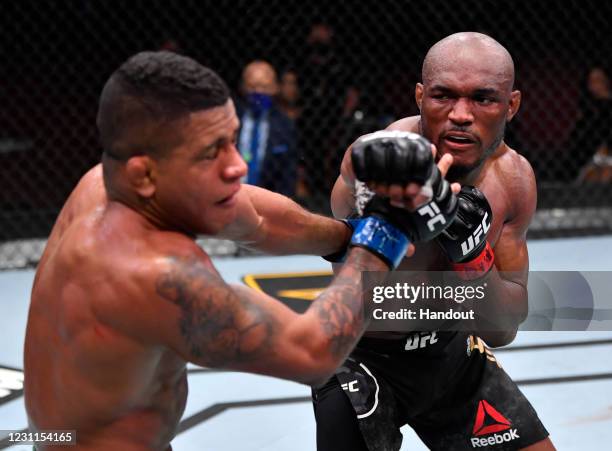 In this handout image provided by UFC, Kamaru Usman of Nigeria punches Gilbert Burns of Brazil in their UFC welterweight championship fight during...