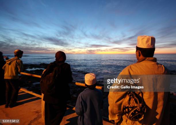 Members of the Islamic community look out to sea from the Sea Point beach front during the sighting of the new moon which marks the end of the month...