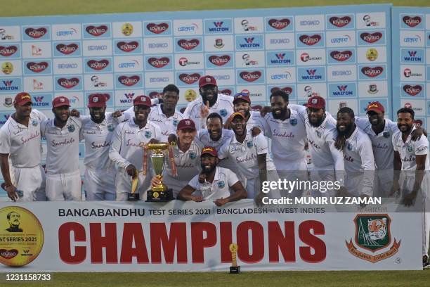 West Indies' players pose with the Test tournament trophy after winning the second Test cricket match against Bangladesh at the Sher-e-Bangla...