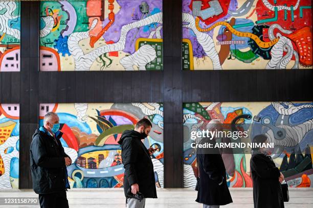 Kosovo Albanians wait in line to cast their vote during Parliamentary elections at a polling station in Pristina on February 14, 2021. - Kosovo heads...