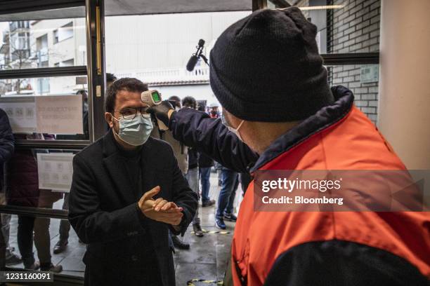 Pere Aragones, candidate for Esquerra Republicana de Catalunya , has his temperature checked as he arrives at a polling station in Barcelona, Spain,...