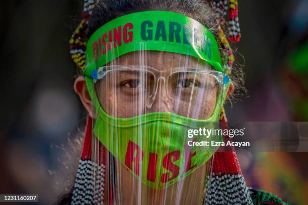 Woman wearing a facemask and face shield to protect against COVID-19 dances to take part in the One Billion Rising global campaign to end violence...