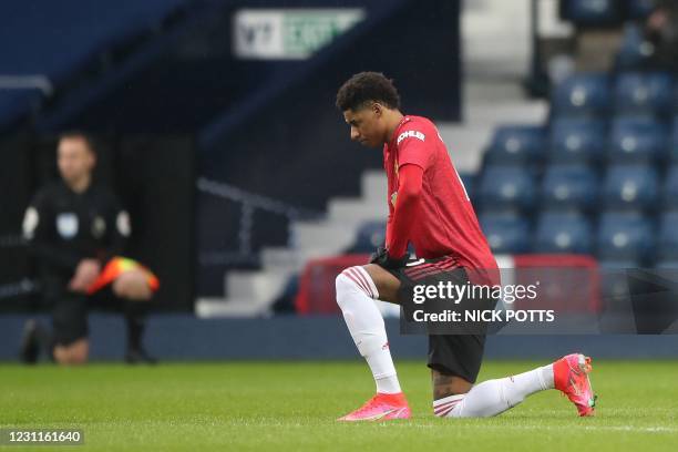 Manchester United's English striker Marcus Rashford takes a knee against racism at the end of the English Premier League football match between West...