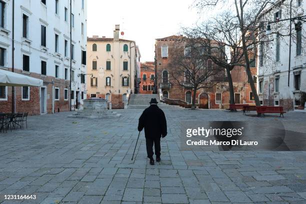 An elderly man walks alone in an empty square on February 14, 2021 in Venice, Italy. Venice is marking a second Carnival period upended by the...