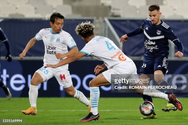 Marseille's Japanese defender Yuto Nagatomo and Marseille's French defender Boubacar Kamara fights for the ball with Bordeaux's French forward Remi...