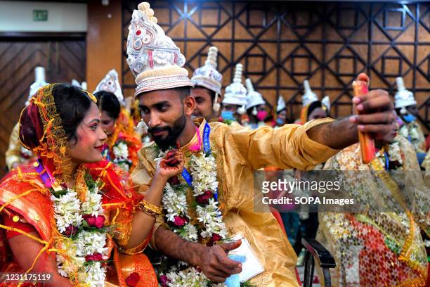 Couple takes a selfie during the Mass Marriage ceremony. An NGO called "Aloy Phera" organised a Mass marriage ceremony of 70 Couples from different...
