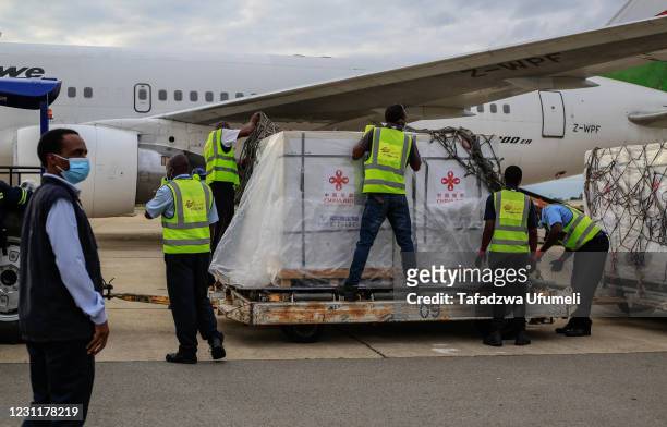 Airport employees unseal a shipment of Sinopharm Covid-19 vaccine at the Harare International Airport on February 15, 2021 in Harare, Zimbabwe. The...