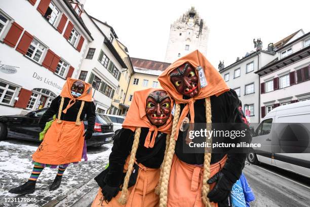 February 2021, Baden-Wuerttemberg, Ravensburg: Some fools of the Schwarze Veri Zunft Ravensburg walk through the Obertor at ten o'clock sharp. The...