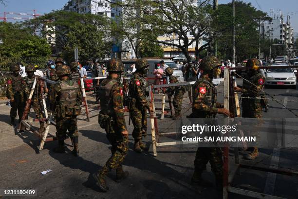 Soldiers prepare to block a road in front of the Central Bank of Myanmar in Yangon on February 15 as Myanmar's junta deployed extra troops around the...