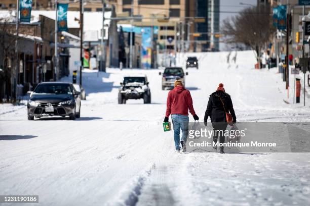 People carry groceries from a local gas station on February 15, 2021 in Austin, Texas. Winter storm Uri has brought historic cold weather to Texas,...