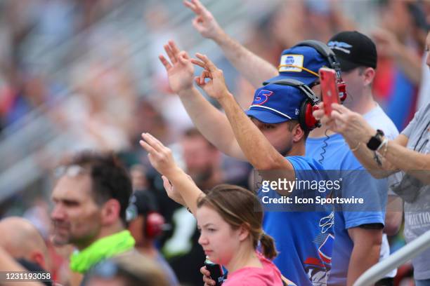 Fans hold up three fingers to salute NASCAR legend Dale Earnhardt, who passed away 20 years ago, during the Daytona 500 on February 14, 2021 at...