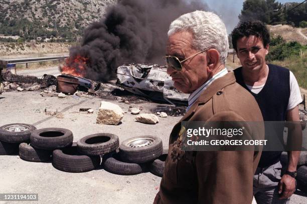 Un vieil Harki portant l'uniforme français avec ses décorations, se tient devant une barricade érigée par des enfants de Harkis, le 25 juin 1991 sur...