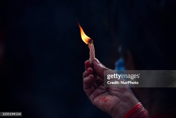 Nepalese devotee offering butter lamp at the premises of Saraswati temple during Basant Panchami or Shree Panchami Festival celebrated in Kathmandu,...