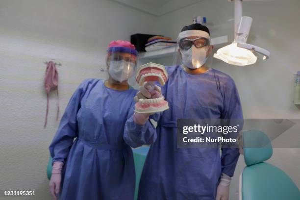 Angélica Martínez and Ayax Malacate, dental surgeons, attend to a patient who attended a dental cleaning during the health emergency and orange...