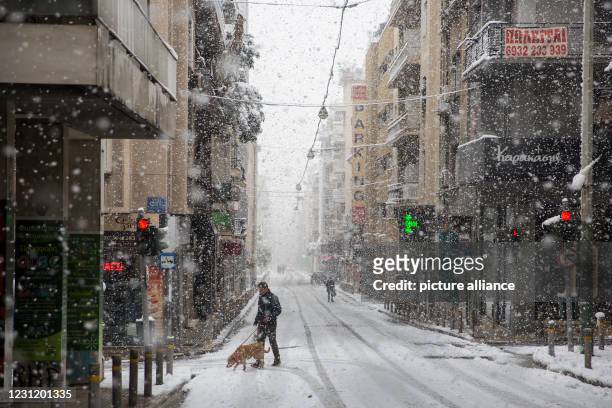 February 2021, Greece, Athen: People walking during a snowstorm. Photo: Socrates Baltagiannis/