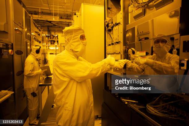 Employees work on production control in the clean room at the Globalfoundries semiconductor fabrication plant in Dresden, Germany, on Thursday, Feb....
