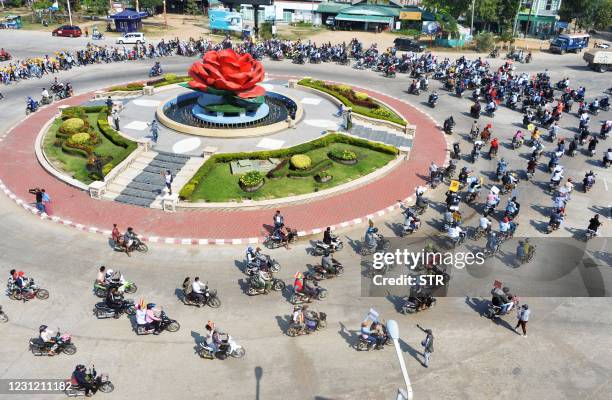 Protesters on scooters go around a major roundabout during a demonstration against the military coup in Naypyidaw on February 17, 2021.