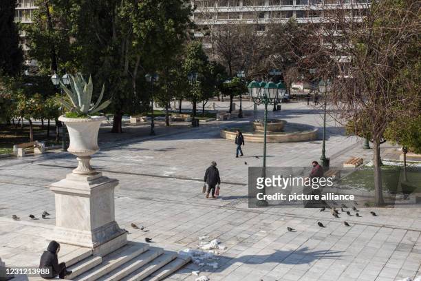 February 2021, Greece, Athen: Only a few people are walking on Syntagma Square. A strict lockdown has been in effect for the greater Athens area for...