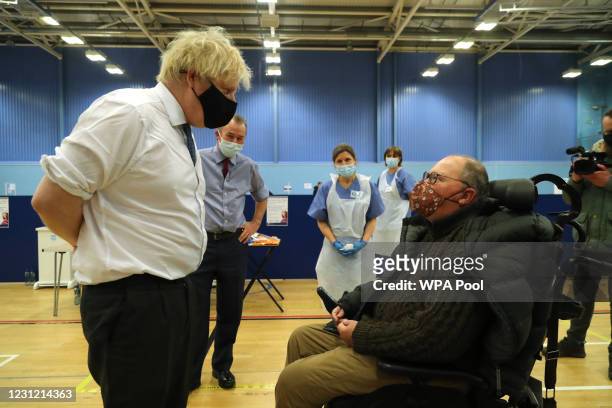 British Prime Minister Boris Johnson speaks with a member of the public as they wait to receive an Oxford/Astrazeneca vaccine during a visit to the...