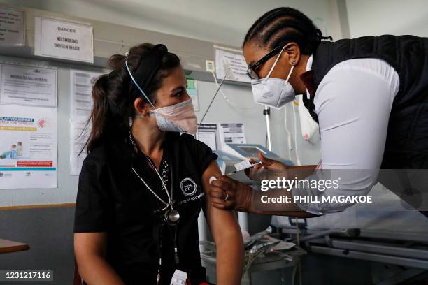 Doctor Anike Baptiste receives a dose of the Johnson & Johnson vaccine against the COVID-19 coronavirus from Mokgadi Malebye, a professional nurse,...