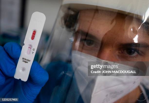 Health professional poses with a test cassette used for an antigen rapid test for the coronavirus at a testing center in Berlin on February 17, 2021.