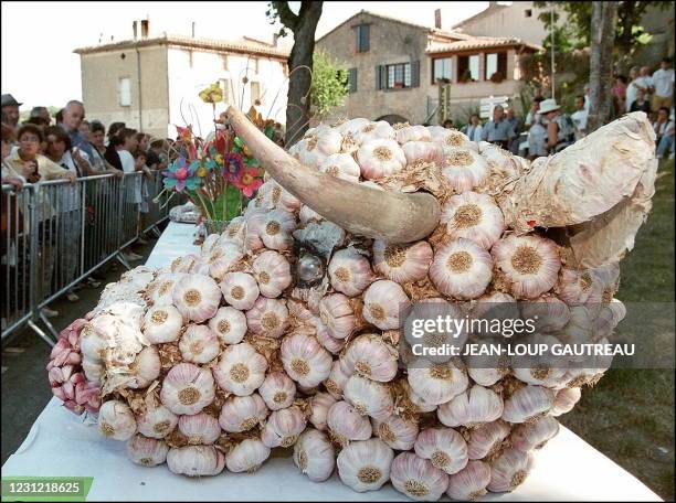 Des personnes regardent, le 01 août à Lautrec, une tête de taureau entièrement réalisée avec des têtes d'ail rose, spécialité locale, lors de la fête...