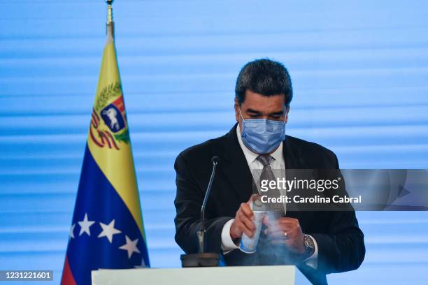 Nicolas Maduro President of Venezuela disinfects his podium with alcohol spray before he speaks in a press conference at Miraflores Palace on...